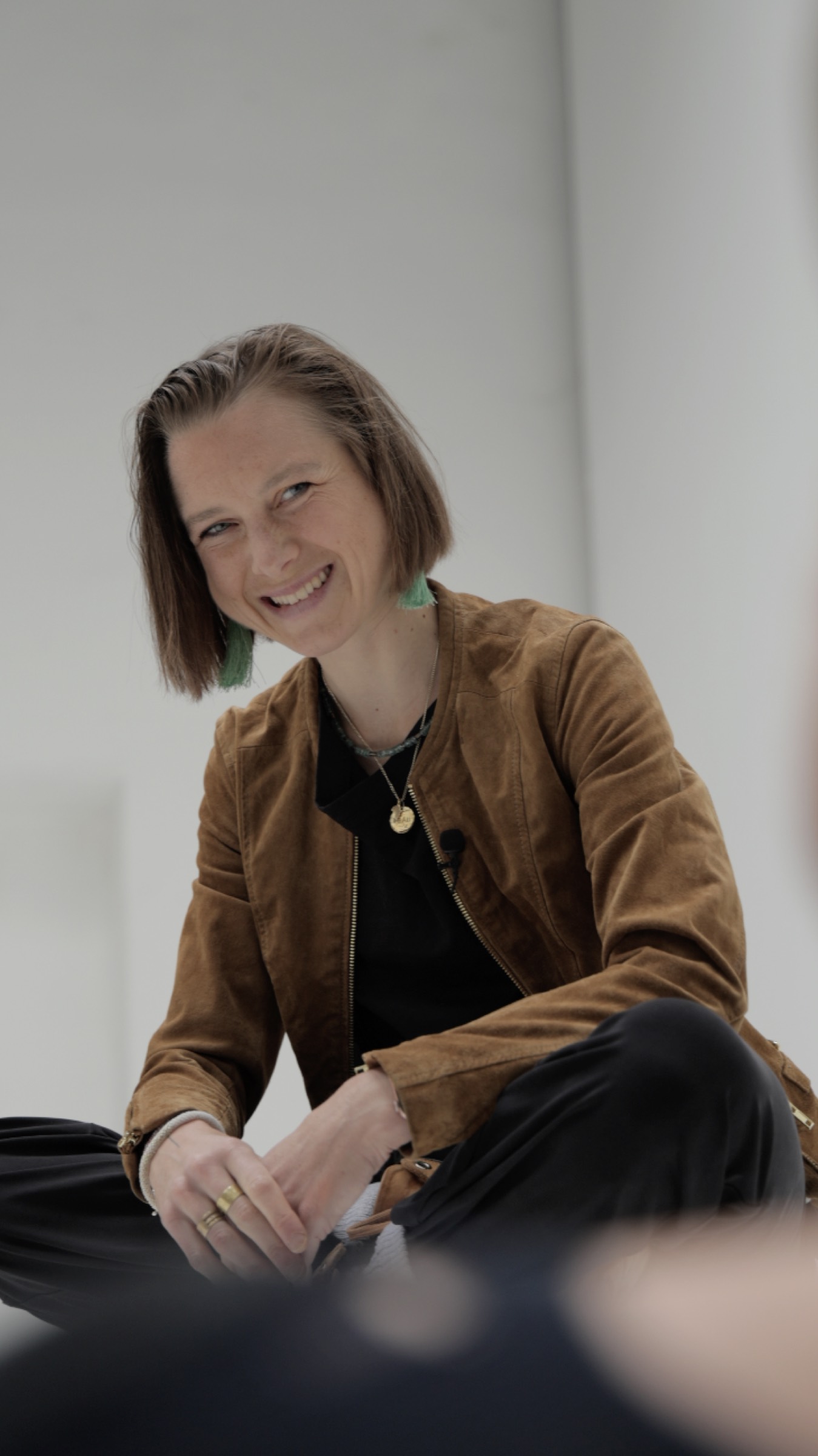 Sophie Friedrich sitzt im Schneidersitz und lacht